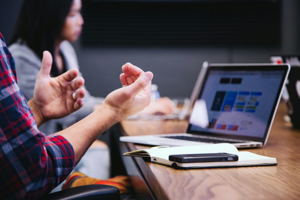 Man gesturing in front of laptop